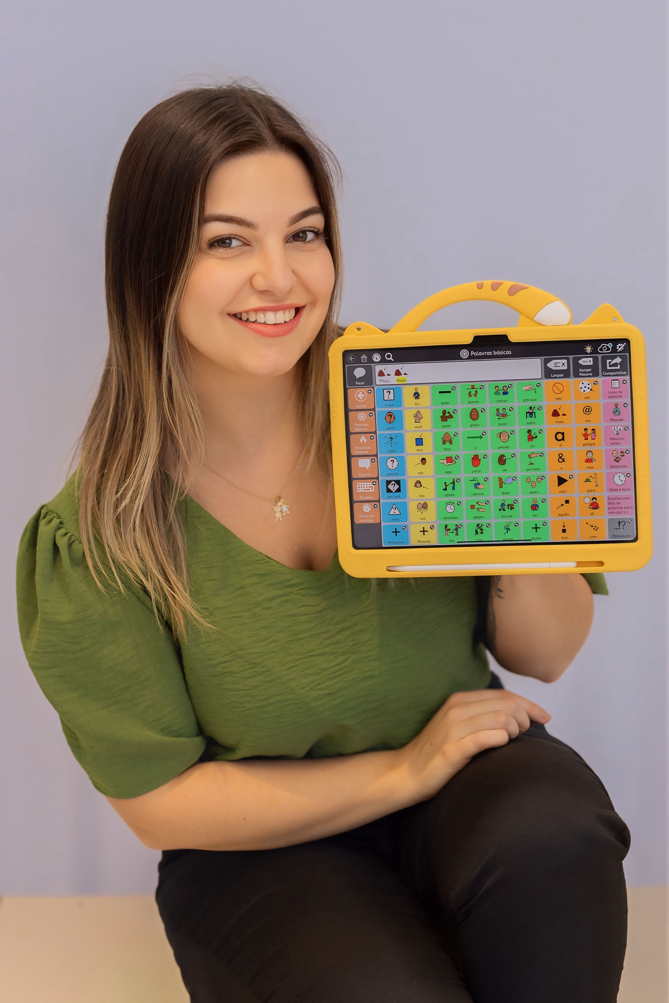 Fga. Dra. Allessandra Fraga Da Ré — fonoaudióloga especialista em CAA, segurando um tablet com aplicativo de CAA